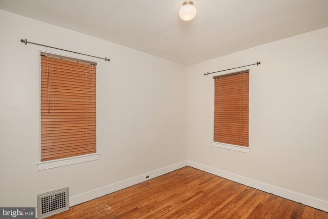 empty room featuring baseboards and wood finished floors