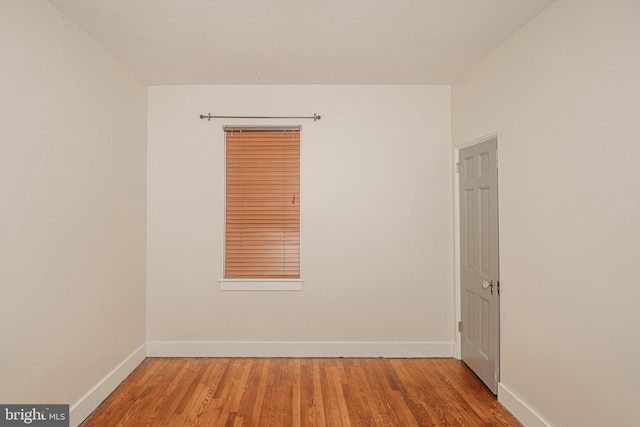 empty room with baseboards and wood finished floors