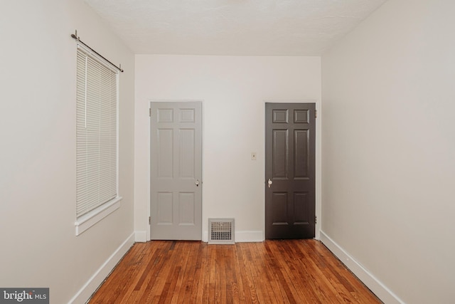unfurnished bedroom featuring wood finished floors and baseboards