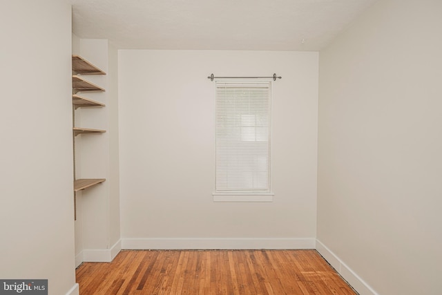 unfurnished room featuring baseboards and wood finished floors