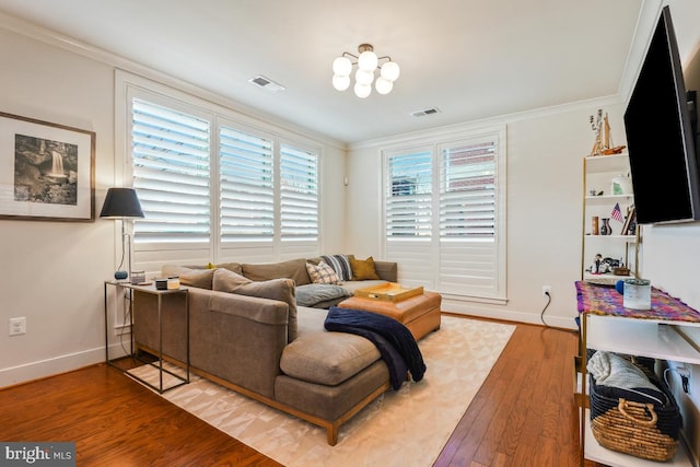 living area with wood finished floors, baseboards, and crown molding