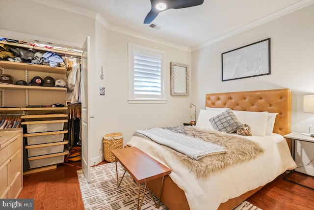 bedroom featuring crown molding, wood finished floors, and ceiling fan