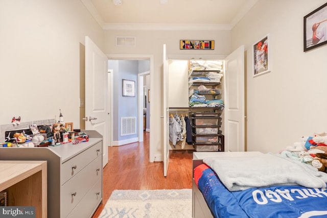 bedroom with light wood finished floors and ornamental molding