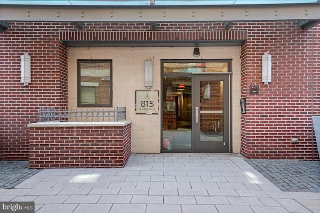 doorway to property featuring brick siding