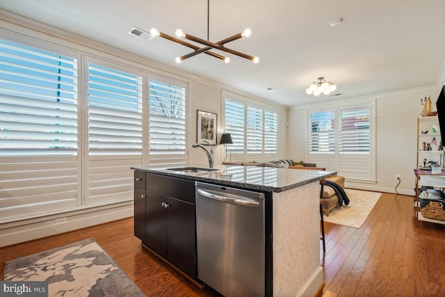 kitchen featuring stainless steel dishwasher, ornamental molding, a sink, dark stone countertops, and wood finished floors