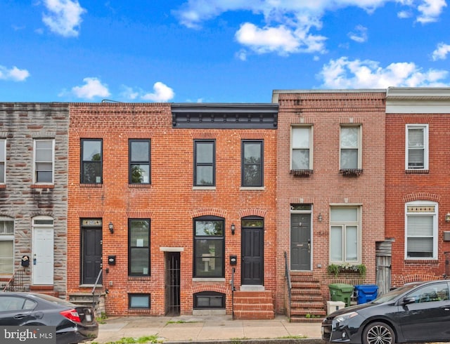 view of property featuring entry steps and brick siding