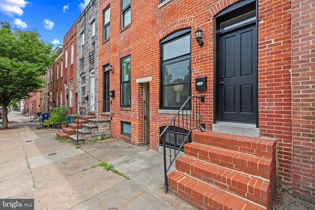 view of exterior entry with brick siding