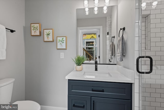 full bathroom with toilet, vanity, and a shower stall