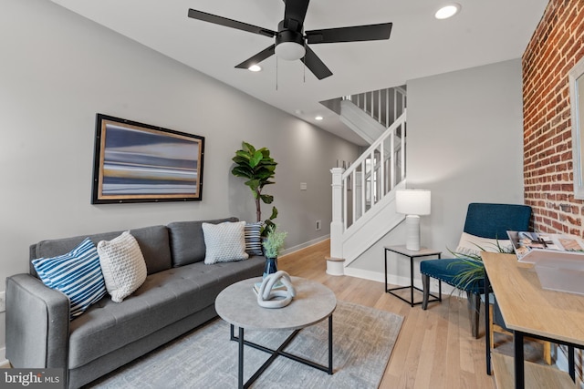 living area featuring stairway, light wood-type flooring, ceiling fan, baseboards, and recessed lighting