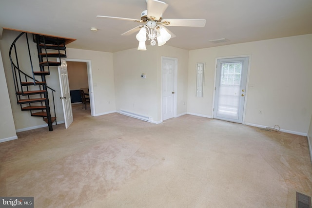20560 Nanticoke Rd, Nanticoke, MD 21840 - unfurnished living room with stairs, a baseboard radiator, a ceiling fan, and light carpet