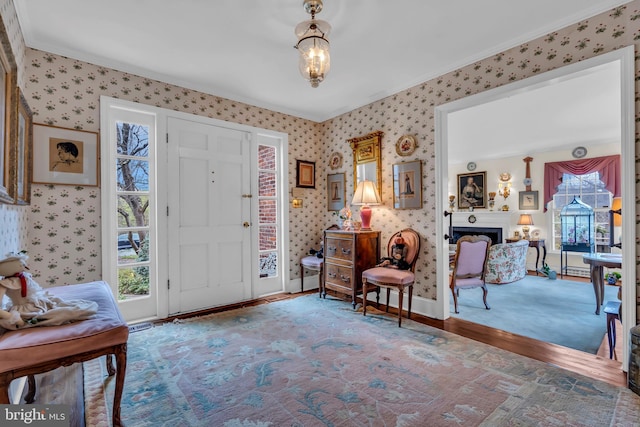 607 Rosedale Rd, Princeton, NJ 08540 - entryway with wallpapered walls, ornamental molding, wood finished floors, a fireplace, and baseboards