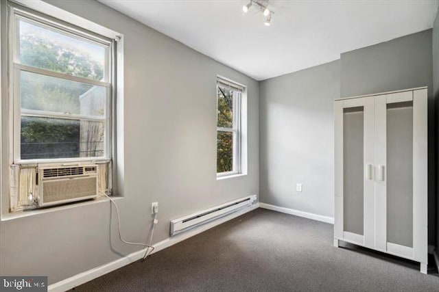 unfurnished bedroom with baseboard heating, cooling unit, baseboards, carpet flooring, and a closet