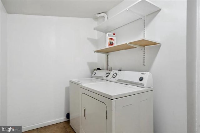 laundry room featuring washer and clothes dryer, baseboards, and light tile patterned flooring