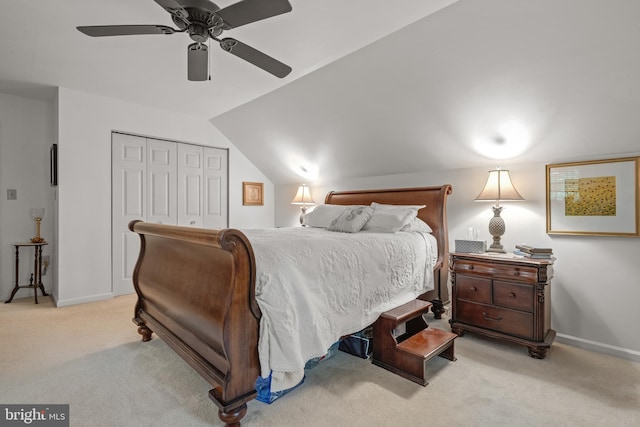 carpeted bedroom featuring a closet, baseboards, vaulted ceiling, and a ceiling fan