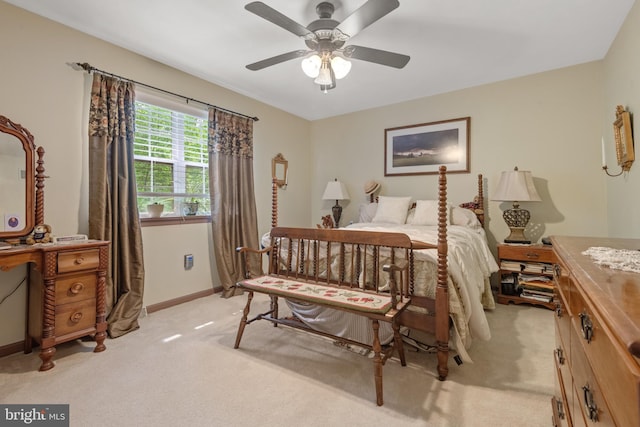 bedroom featuring light colored carpet, baseboards, and a ceiling fan