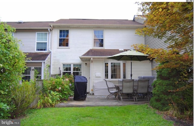 back of house with a patio area and a lawn
