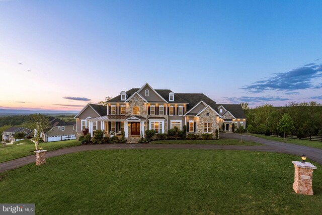16024 Waterford Crest Pl, Paeonian Springs, VA 20129 - view of front of property featuring stone siding, curved driveway, covered porch, a lawn, and a standing seam roof