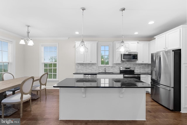 16024 Waterford Crest Pl, Paeonian Springs, VA 20129 - kitchen featuring stainless steel appliances, a sink, dark countertops, a kitchen island, and crown molding