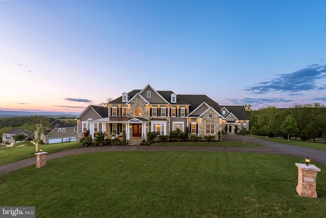 16024 Waterford Crest Pl, Paeonian Springs, VA 20129 - view of front of property featuring stone siding, curved driveway, covered porch, a lawn, and a standing seam roof
