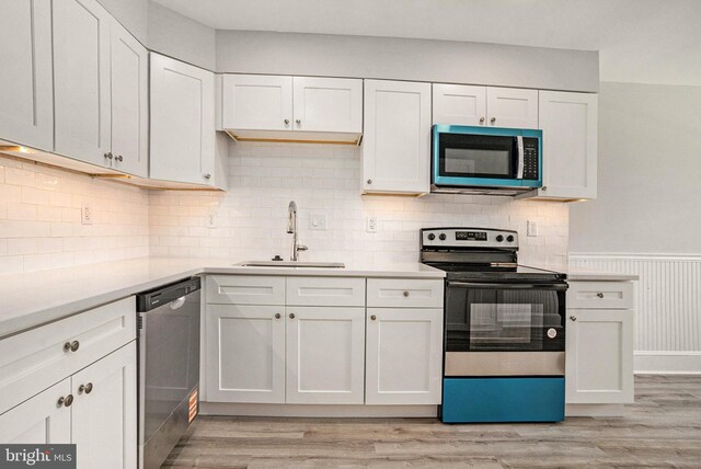 748 Jefferson St, Red Hill, PA 18076 - kitchen featuring stainless steel appliances, a sink, light wood-type flooring, light countertops, and wainscoting