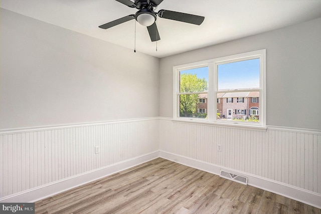748 Jefferson St, Red Hill, PA 18076 - empty room featuring light wood-type flooring, a wainscoted wall, and a ceiling fan