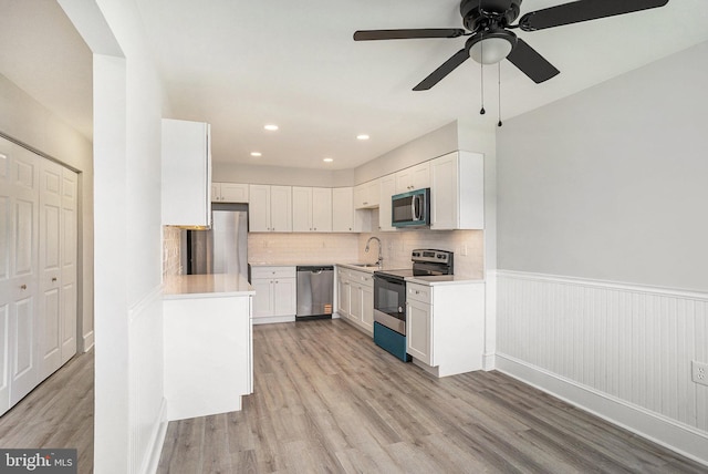 748 Jefferson St, Red Hill, PA 18076 - kitchen with appliances with stainless steel finishes, a sink, light wood finished floors, light countertops, and wainscoting