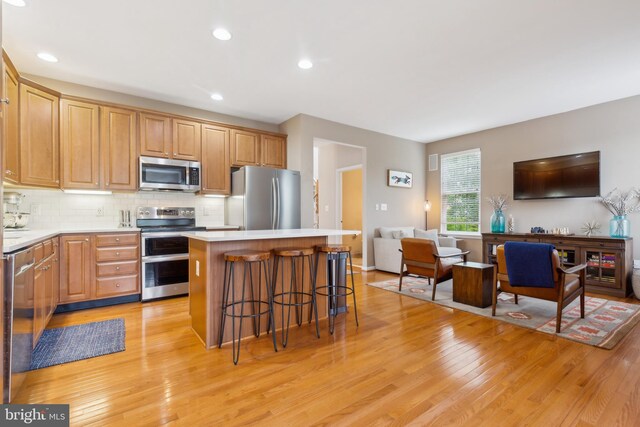 22615 Upperville Heights Sq, Ashburn, VA 20148 - kitchen featuring stainless steel appliances, a center island, light wood-style flooring, a kitchen breakfast bar, and recessed lighting