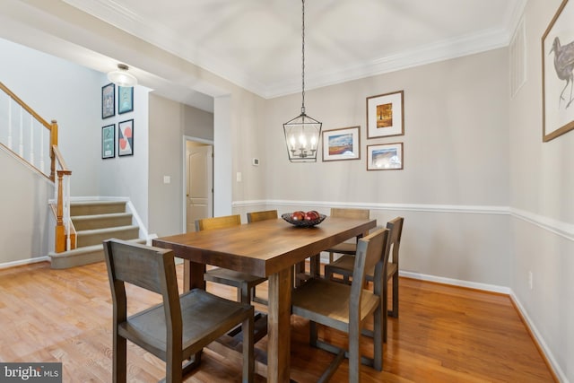 22615 Upperville Heights Sq, Ashburn, VA 20148 - dining area featuring stairs, a chandelier, light wood-style flooring, ornamental molding, and baseboards