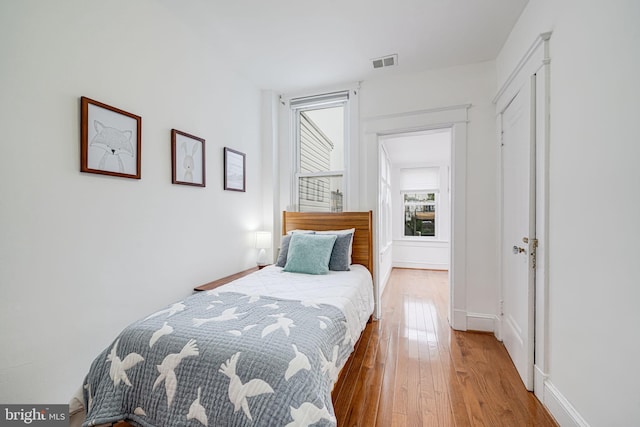 bedroom with wood-type flooring and baseboards