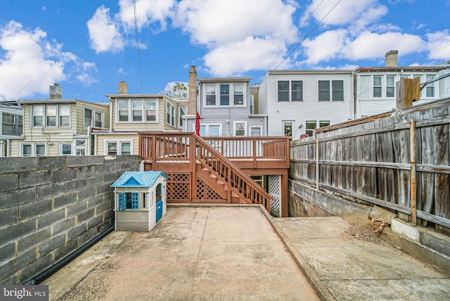 back of property with a wooden deck, a fenced backyard, a residential view, and a patio