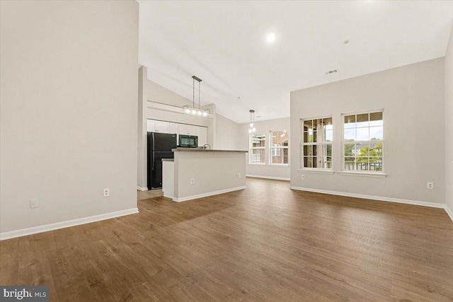2400 Dominion Dr Unit 3D, Frederick, MD 21702 - unfurnished living room featuring wood finished floors, baseboards, a sink, high vaulted ceiling, and a chandelier