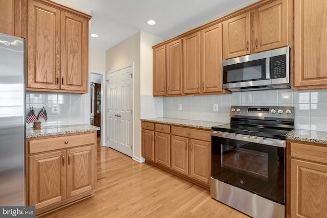 42522 Neighborly Ln, Chantilly, VA 20152 - kitchen with appliances with stainless steel finishes, backsplash, light wood-style floors, light stone counters, and recessed lighting
