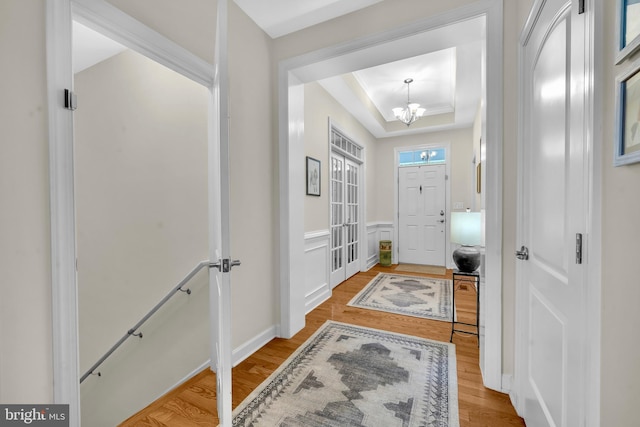 2906 Cornus Way, Joppa, MD 21085 - entryway featuring a tray ceiling, a chandelier, wood finished floors, and wainscoting