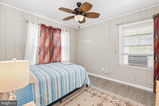 1004 Philadelphia Ave, Ocean City, MD 21842 - bedroom with ornamental molding, cooling unit, wood finished floors, baseboards, and wooden walls