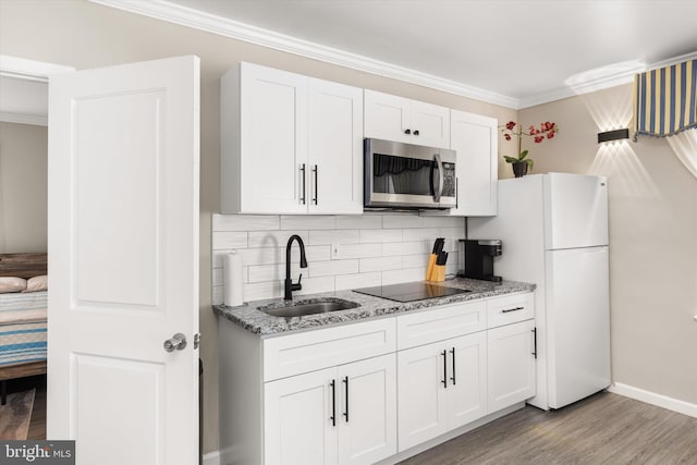 1004 Philadelphia Ave, Ocean City, MD 21842 - kitchen featuring stainless steel microwave, a sink, black electric stovetop, white cabinetry, and light wood finished floors