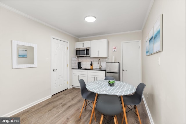 1004 Philadelphia Ave, Ocean City, MD 21842 - dining room featuring crown molding, light wood-type flooring, and baseboards