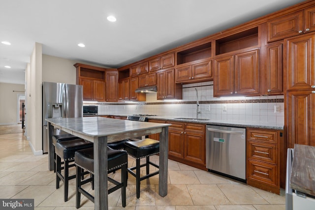kitchen with appliances with stainless steel finishes, a sink, open shelves, under cabinet range hood, and backsplash