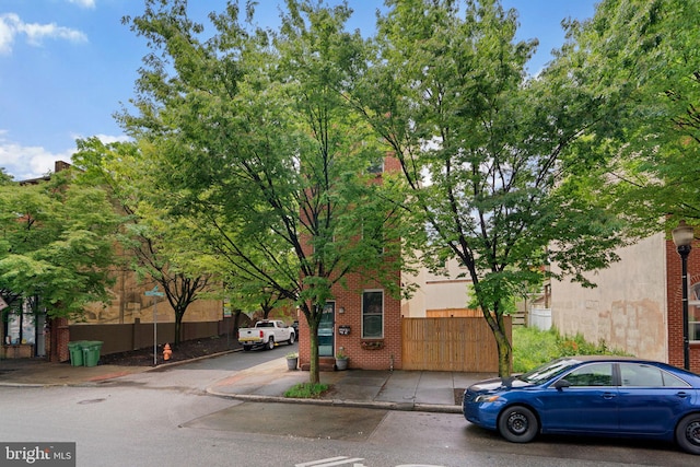 view of front of property with brick siding and fence