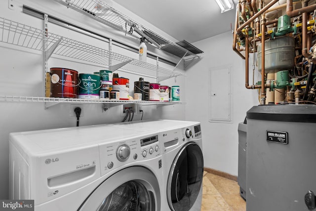 clothes washing area with water heater, independent washer and dryer, and baseboards