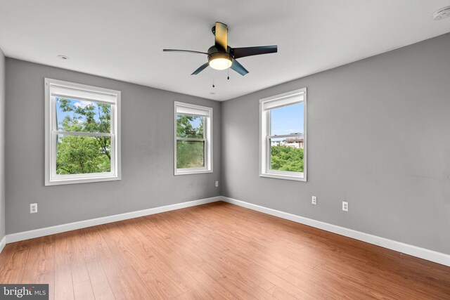 unfurnished room with baseboards, wood finished floors, and a ceiling fan