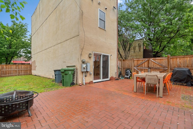 view of patio featuring a fire pit, a fenced backyard, outdoor dining space, and grilling area