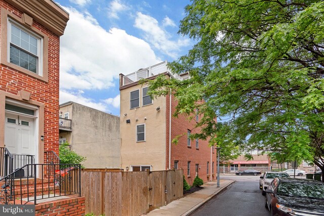 view of side of property with fence and brick siding