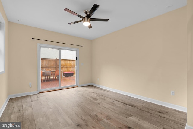 unfurnished room with wood finished floors, ceiling fan, and baseboards