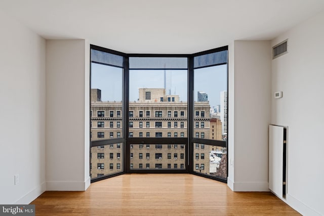 2018 Walnut St Unit 19Gh, Philadelphia, PA 19103 - empty room with floor to ceiling windows, a city view, baseboards, and wood finished floors