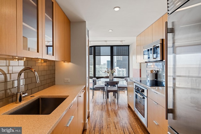 2018 Walnut St Unit 19Gh, Philadelphia, PA 19103 - kitchen with appliances with stainless steel finishes, modern cabinets, a sink, light brown cabinets, and light stone counters