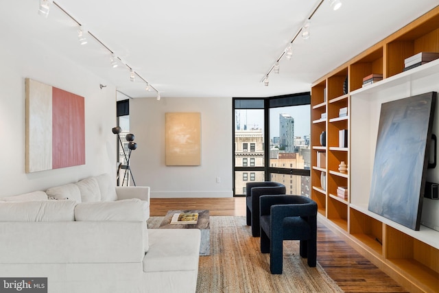 2018 Walnut St Unit 19Gh, Philadelphia, PA 19103 - living room featuring rail lighting, wood finished floors, floor to ceiling windows, baseboards, and a view of city