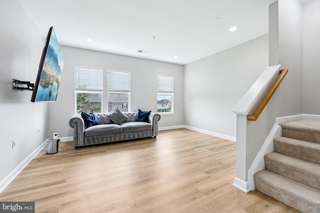 42397 Goldenseal Sq, Brambleton, VA 20148 - living area featuring healthy amount of natural light, light wood finished floors, stairway, recessed lighting, and baseboards