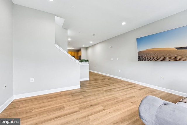 42397 Goldenseal Sq, Brambleton, VA 20148 - unfurnished living room featuring stairway, light wood-type flooring, recessed lighting, and baseboards