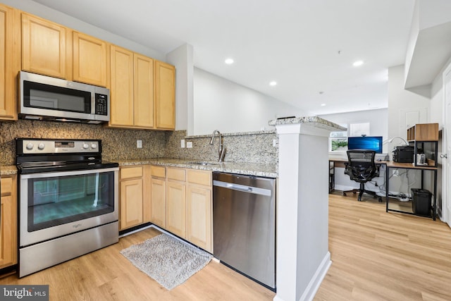 42397 Goldenseal Sq, Brambleton, VA 20148 - kitchen featuring stainless steel appliances, light brown cabinets, a sink, a peninsula, and light wood-type flooring