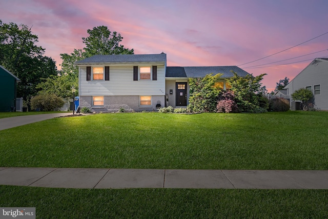 tri-level home with a yard and driveway